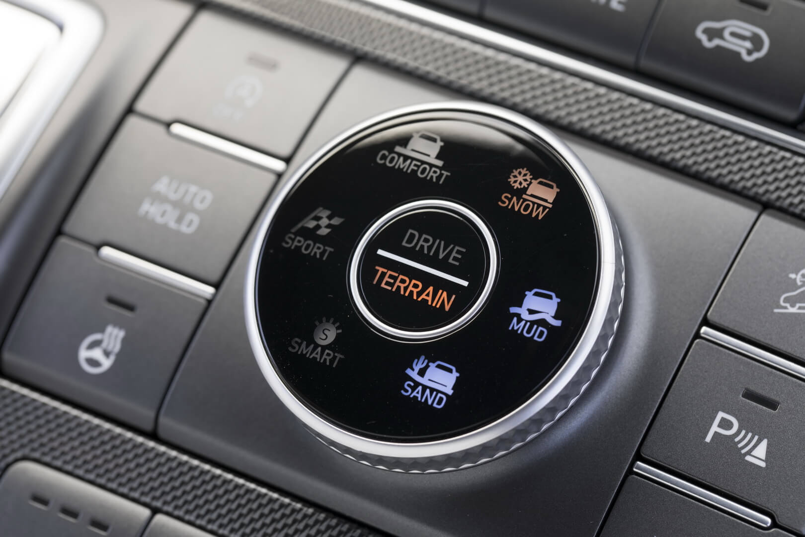 На центральной консоли нового Santa Fe появится переключатель, на котором водители смогут выбирать между четырьмя режимами вождения (Drive Mode) и тремя режимами выбора покрытия (Terrain Mode)